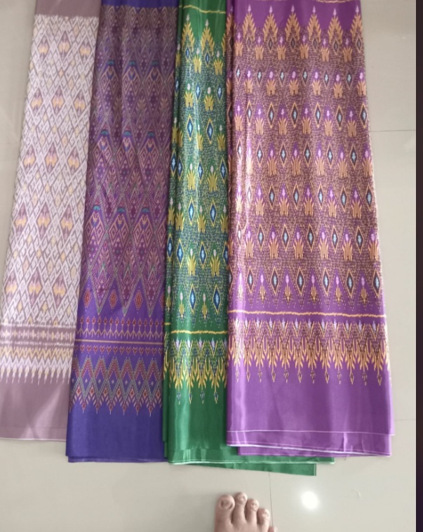 ผ้าสีม่วงและสีเขียวพร้อมลวดลายตกแต่ง